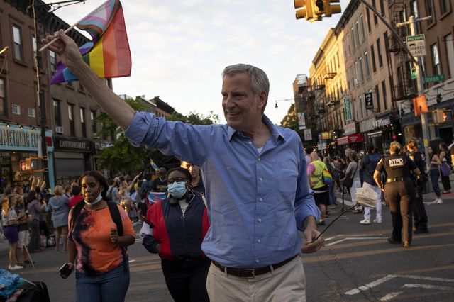 Former Mayor Bill de Blasio holds a gay pride flag as he marchers in the Gay Pride Parade in Manhattan.